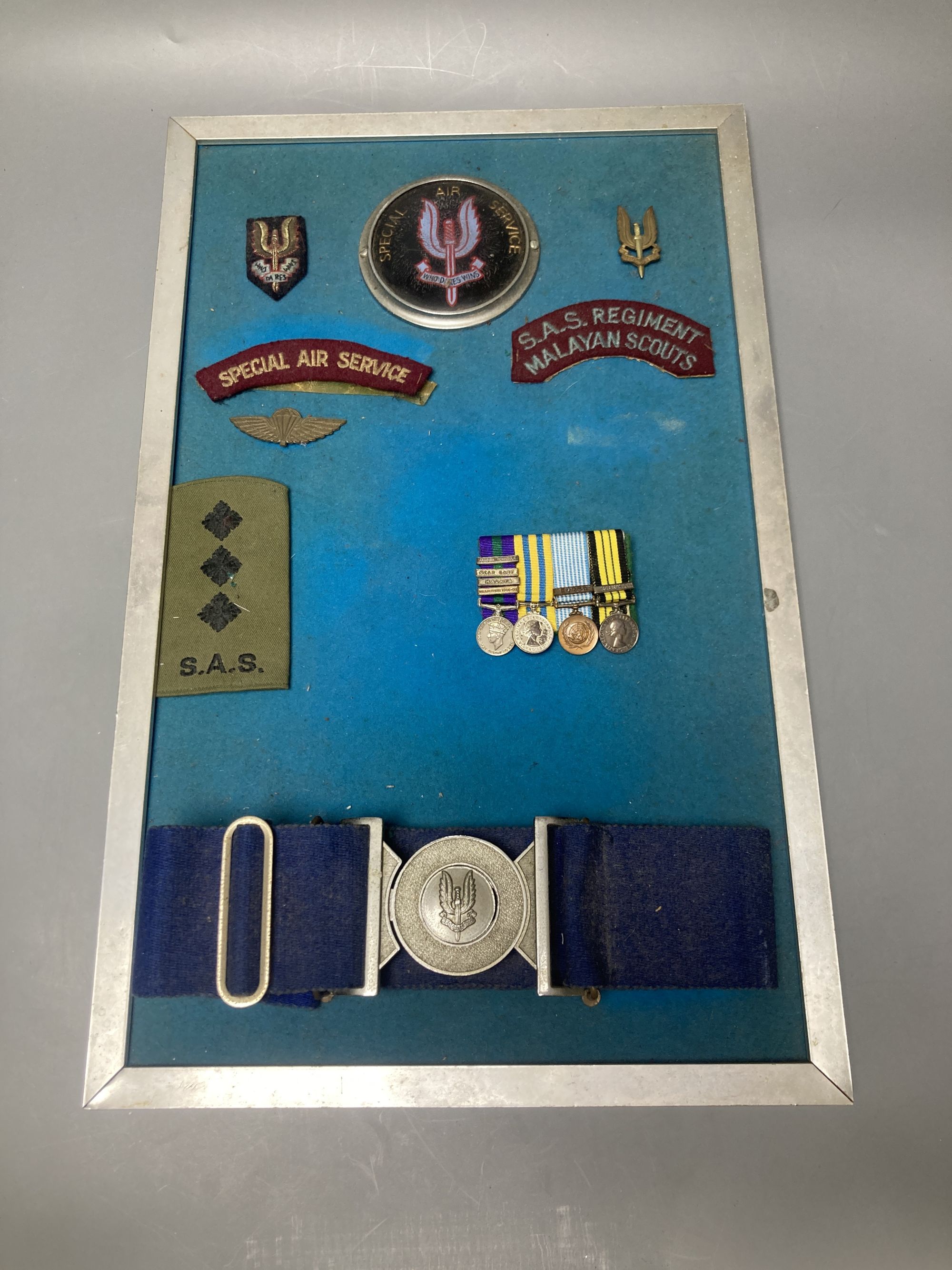 A group of Special Air Service SAS embroidered insignia, a belt and other military items, includes a Malayan Scouts insignia and a group of unnamed miniatures